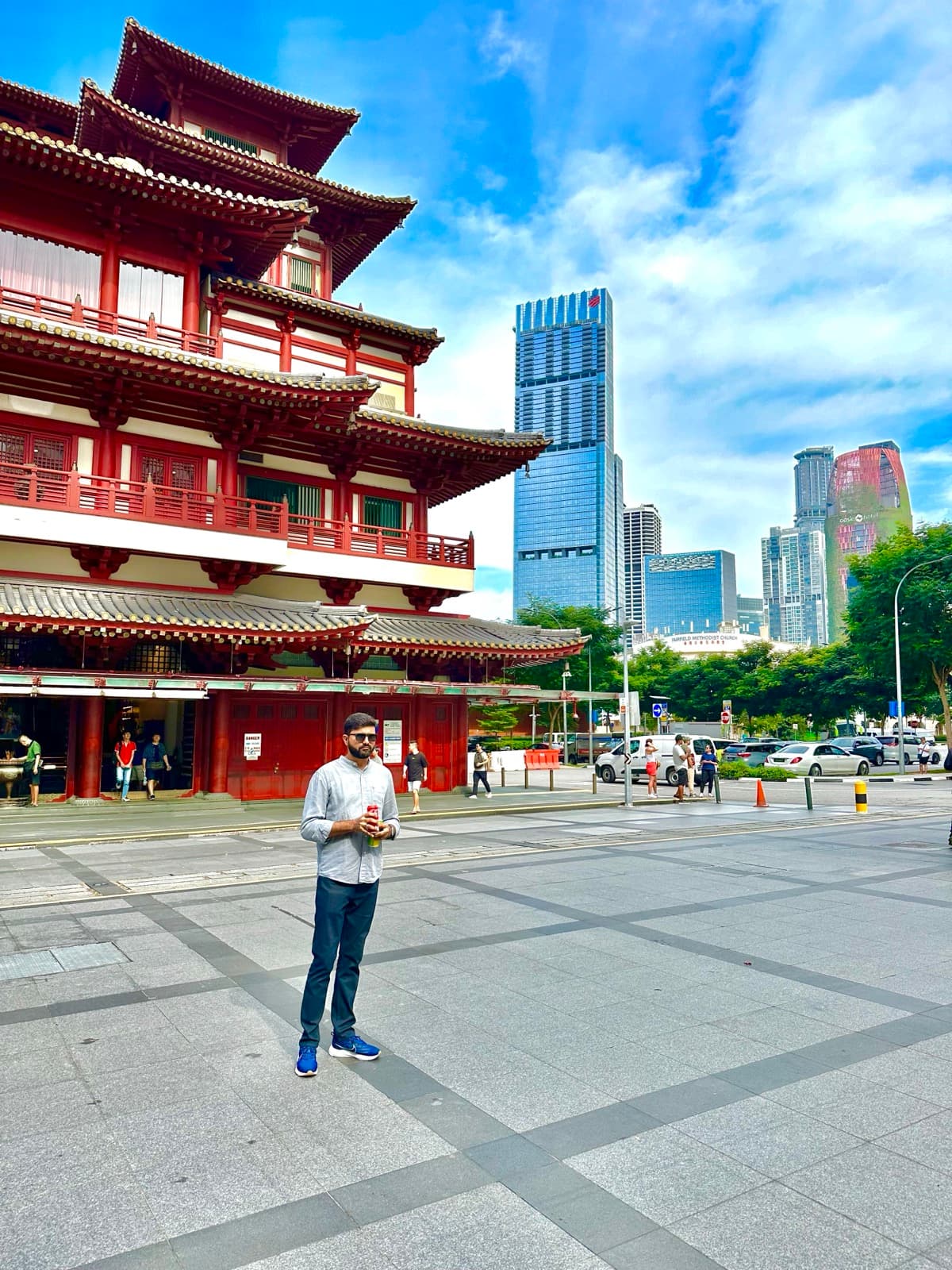 Anand Thakkar in front of the Buddha Tooth Relic Temple with Singapore's skyscrapers behind, 2024